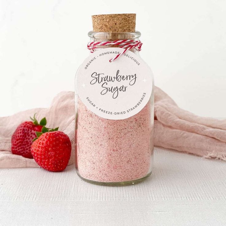 strawberry sugar in a jar next to two strawberries