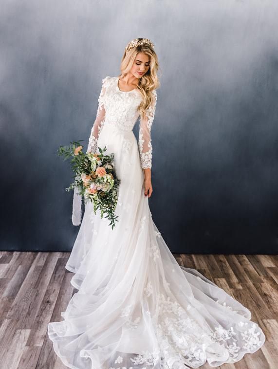 a woman in a wedding dress standing on a wooden floor wearing a flower crown and holding a bouquet