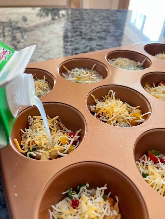 a muffin tin filled with cupcake batters and shredded cheese in it's center