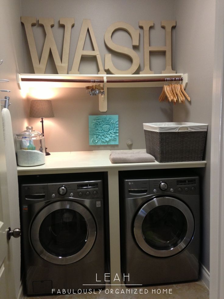 a washer and dryer in a laundry room with baskets on the shelves above them