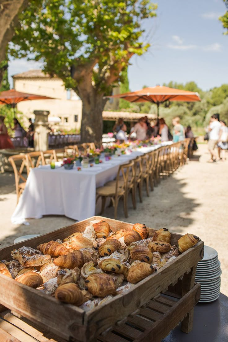 there is a tray full of croissants on the table at this outdoor event