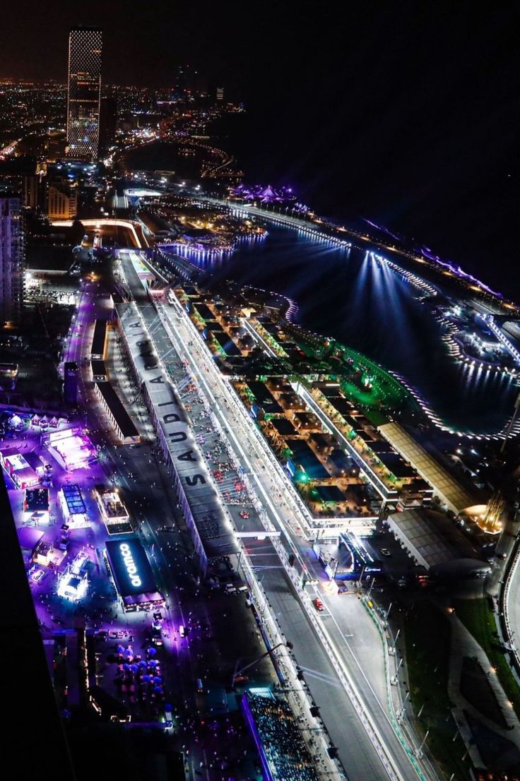 an aerial view of a city at night with lots of lights on the buildings and streets