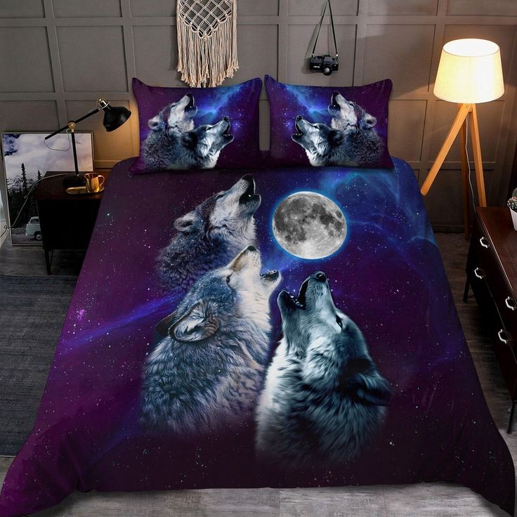 two wolfs are looking up at the moon in this bedding set that is on display