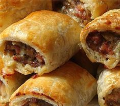 several sausage rolls stacked on top of each other with cheese and meat in the middle