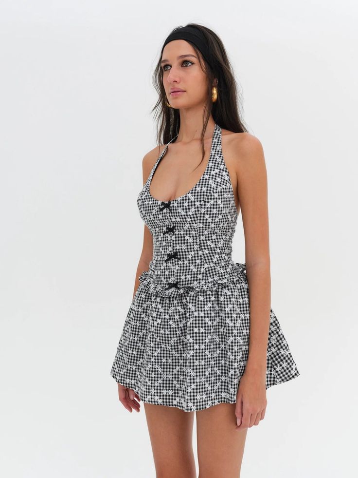 Warm up the Vespa, because we've got the perfect summer dress to zip around in. The Janice black halter dress is crafted in a ditsy gingham fabric—it features a fitted bodice with a mini, gathered skirt. Fit Notes The Janice Halter Mini Dress is fitted through the waist and flares out at the skirt. We recommend taking your usual size. Style Notes Fully lined Decorative satin bows at the center-front bodice Adjustable halter Smocked back bodice Fabric + Care Crafted in 98% polyester, 2% spandex Lining is made of 100% cotton Eco dry clean is recommended to avoid harmful chemicals like "perc" Rosalie Mini Dress, Luxury Cotton Mini Dress, Luxury Summer Mini Dress With Adjustable Straps, Affordable Chic Mini Dress With Lace Trim, Luxury Spring Halter Mini Dress, Christiana Mini Dress, Gabrielle Mini Dress, Luxury Mini Dress With Lace Trim For Spring, Naiya Mini Dress