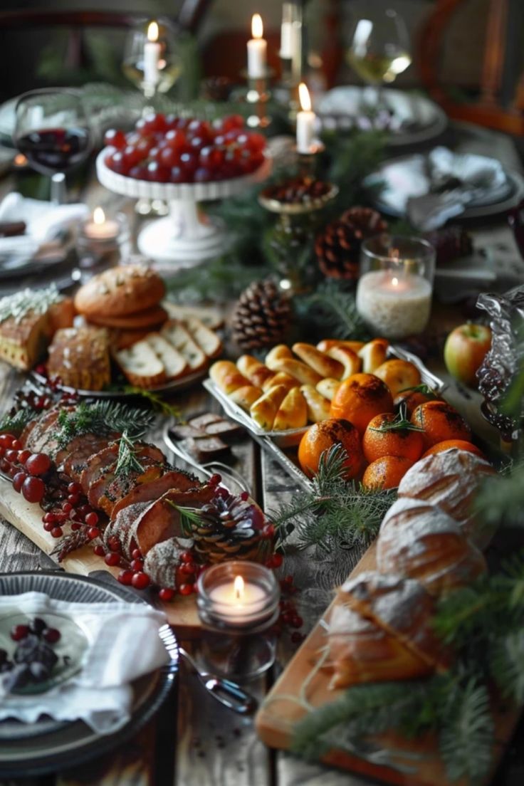 a table topped with lots of food next to candles and plates filled with breads