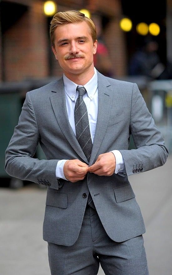 a man in a suit and tie standing on the street