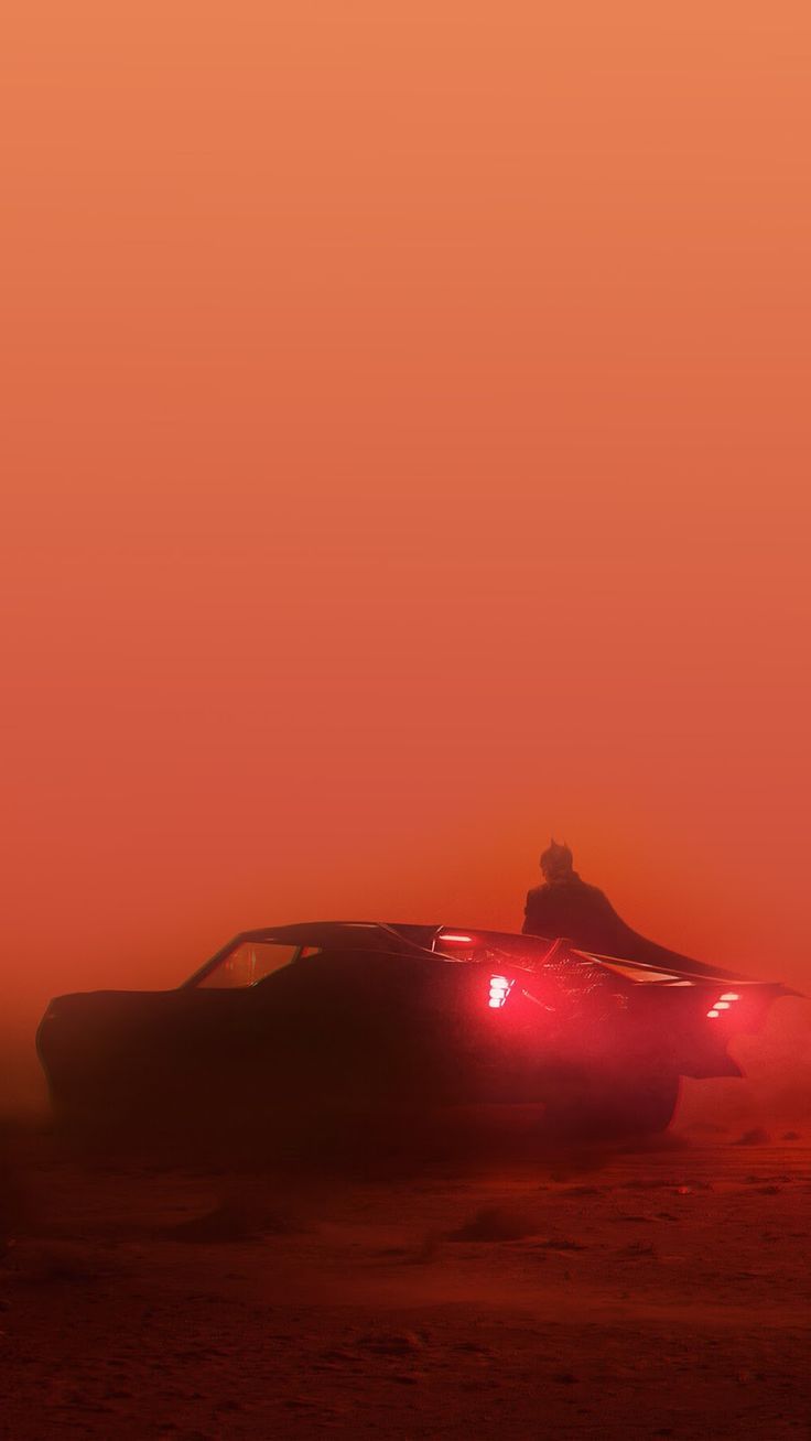 a car driving through the desert at sunset with fog coming off it's hood