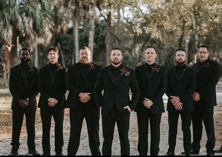 a group of men standing next to each other wearing black tuxedos and bow ties