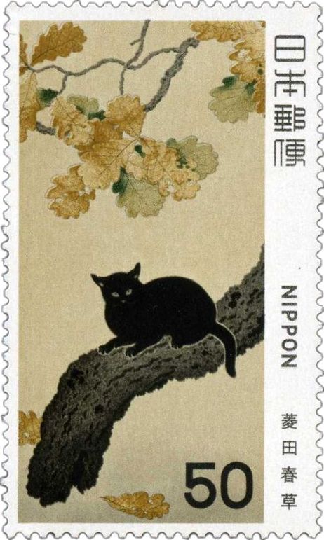 a stamp with a black cat sitting on a tree branch