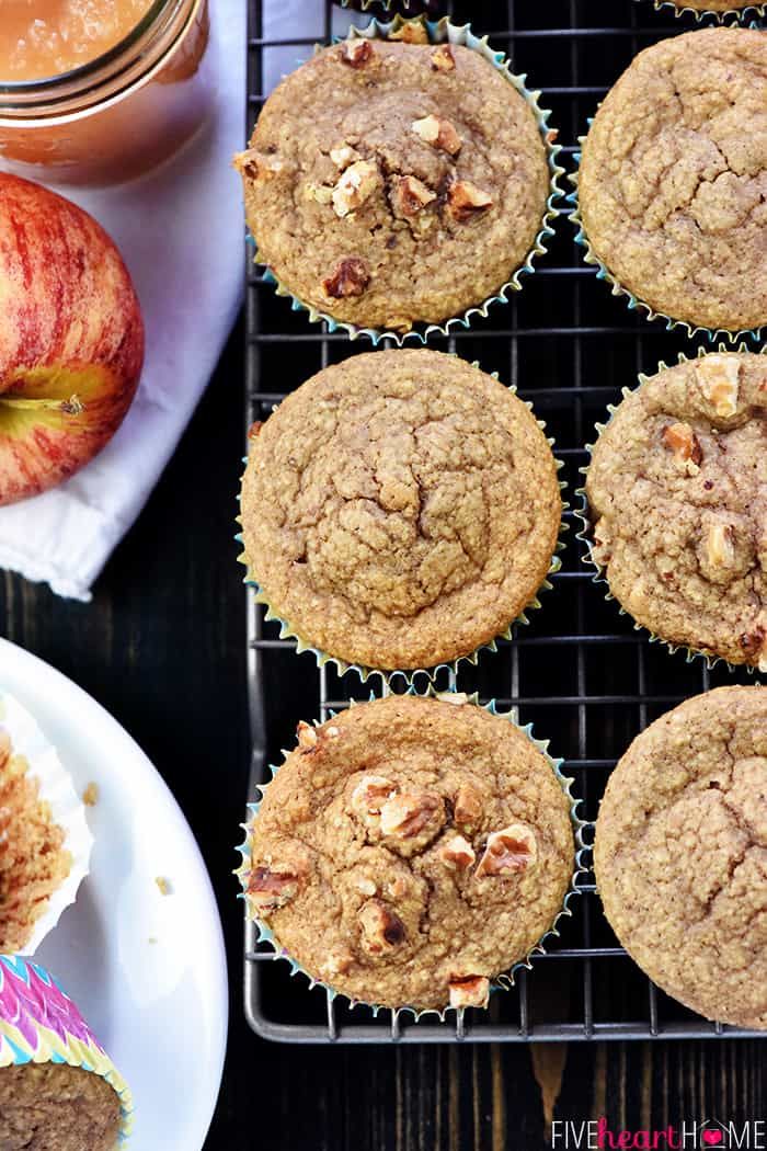 several muffins sitting on top of a cooling rack next to an apple and cupcake