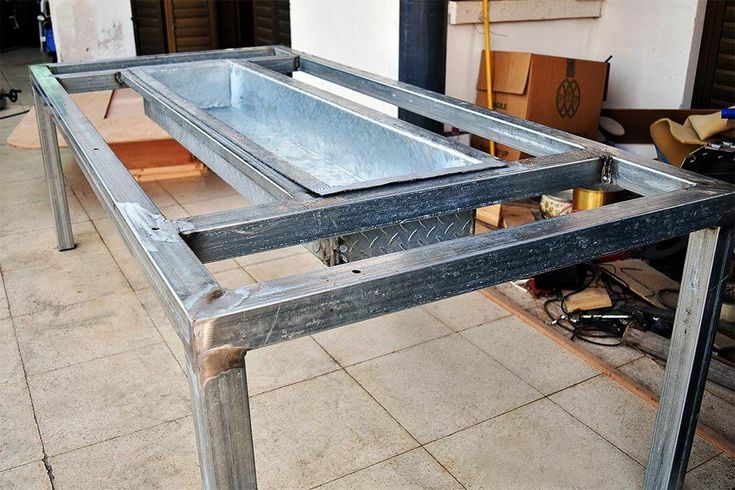 a metal table sitting on top of a tiled floor