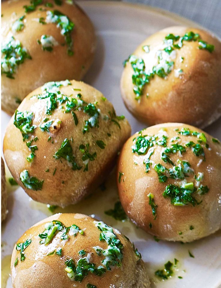 small rolls covered in green herbs on a white plate