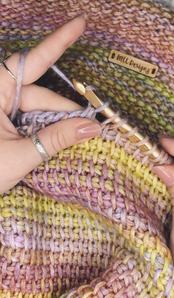 a woman is knitting with crochet needles in her hand and the needle has been pointed