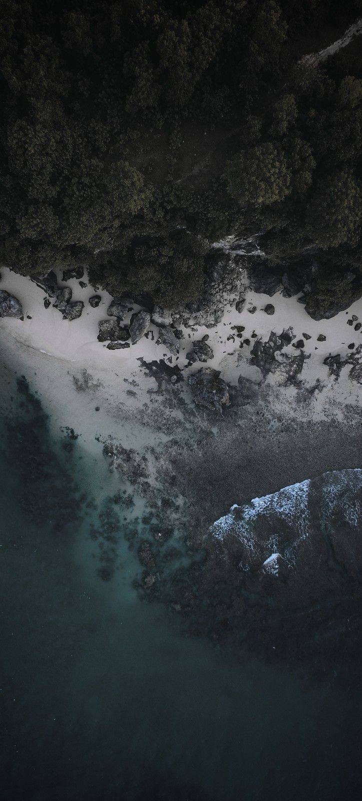 an aerial view of snow covered rocks and water