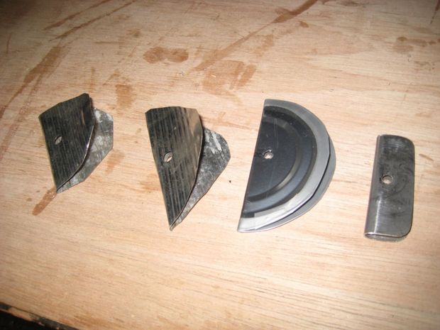 four pieces of metal sitting on top of a wooden table