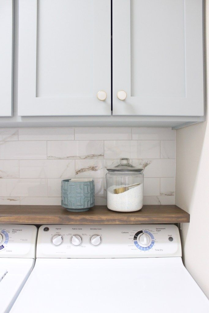 a white washer and dryer sitting in a kitchen next to each other on top of a counter