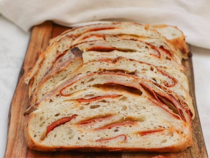 sliced bread with bacon on it sitting on a cutting board