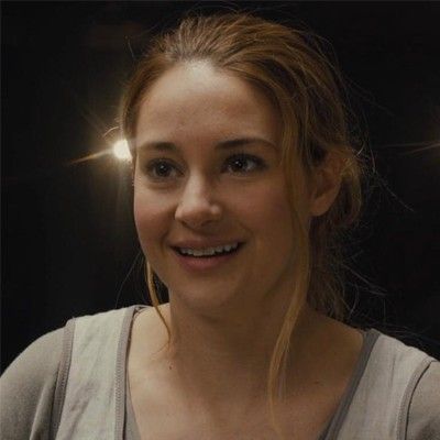 a young woman smiling at the camera in front of some spotlights on her face