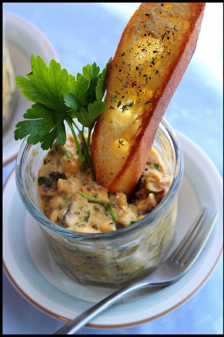 a small glass bowl filled with food on top of a white plate