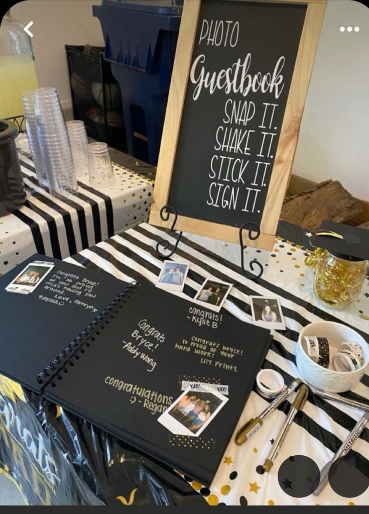 a black and white table topped with lots of food next to a chalkboard sign