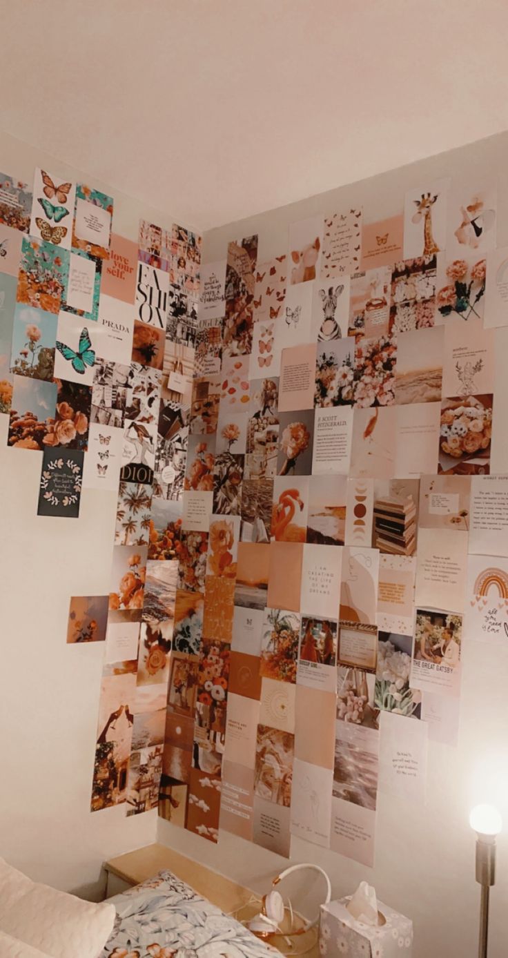 a room with many pictures on the wall and a bed in front of it,