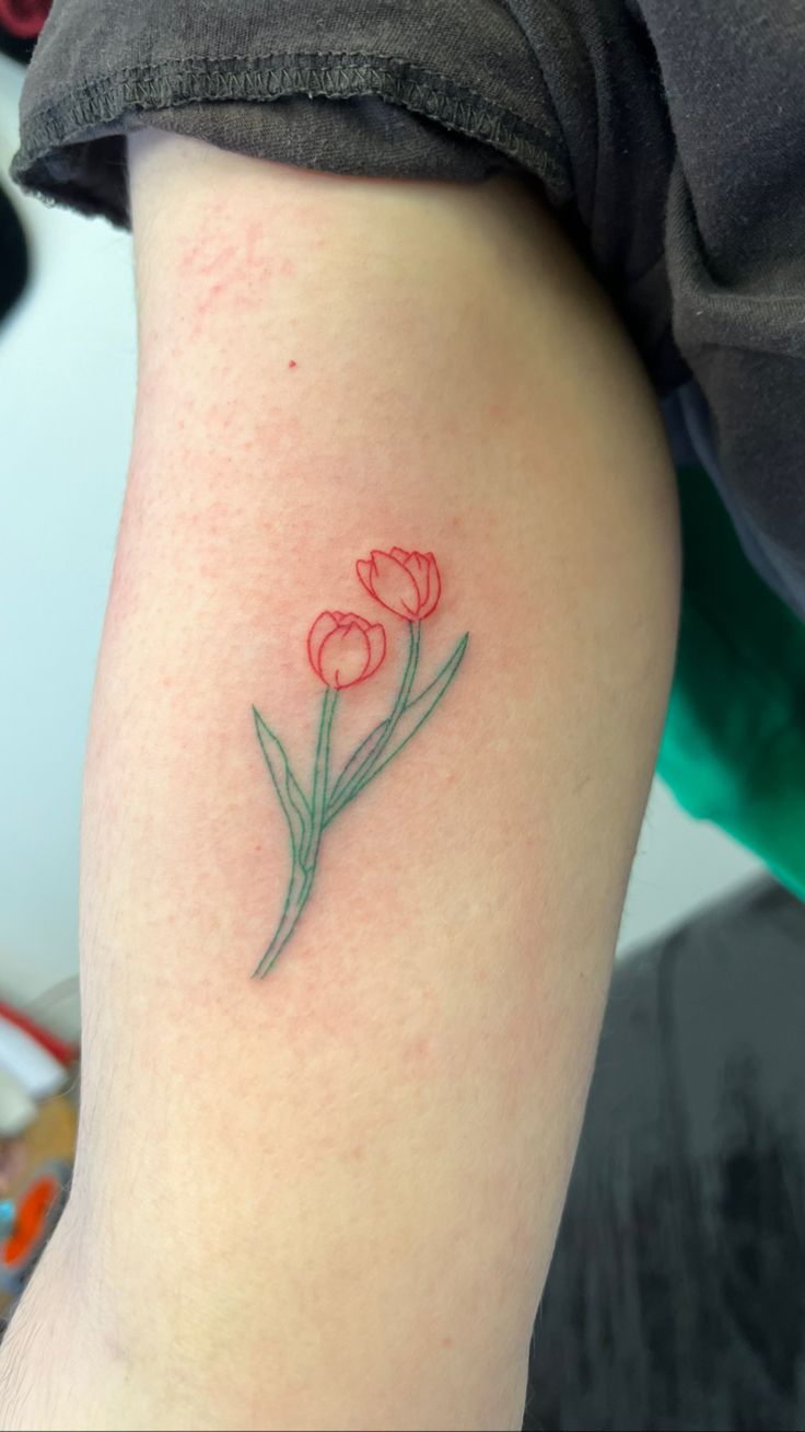 a small red flower tattoo on the right thigh