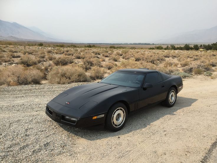 a black sports car is parked in the desert