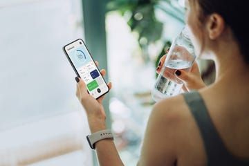 Woman refreshing with water and using calorie counting app on smartphone for good housekeepings best calorie counting app 1200 Calorie Diet Menu, Free Workout Apps, 1200 Calorie Diet Plan, 200 Calorie Meals, Mediterranean Diet Meal Plan, Wellness Apps, 7 Day Meal Plan, Calorie Meal Plan, 1200 Calories