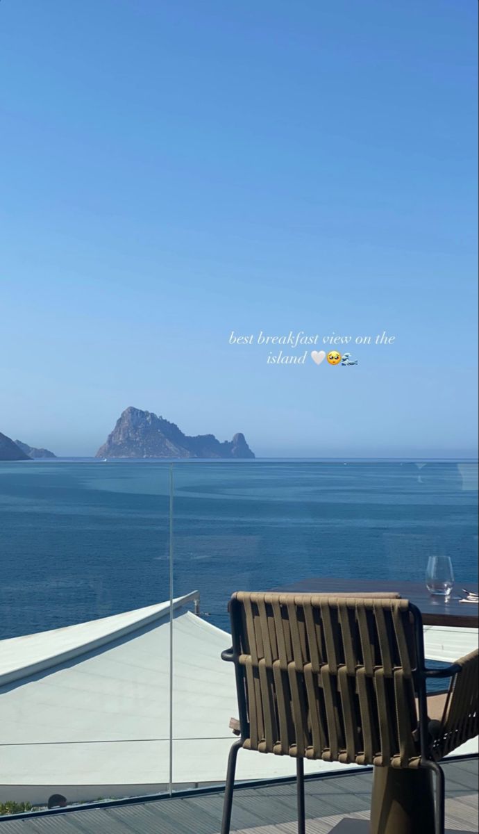 an outdoor table and chairs overlooking the ocean