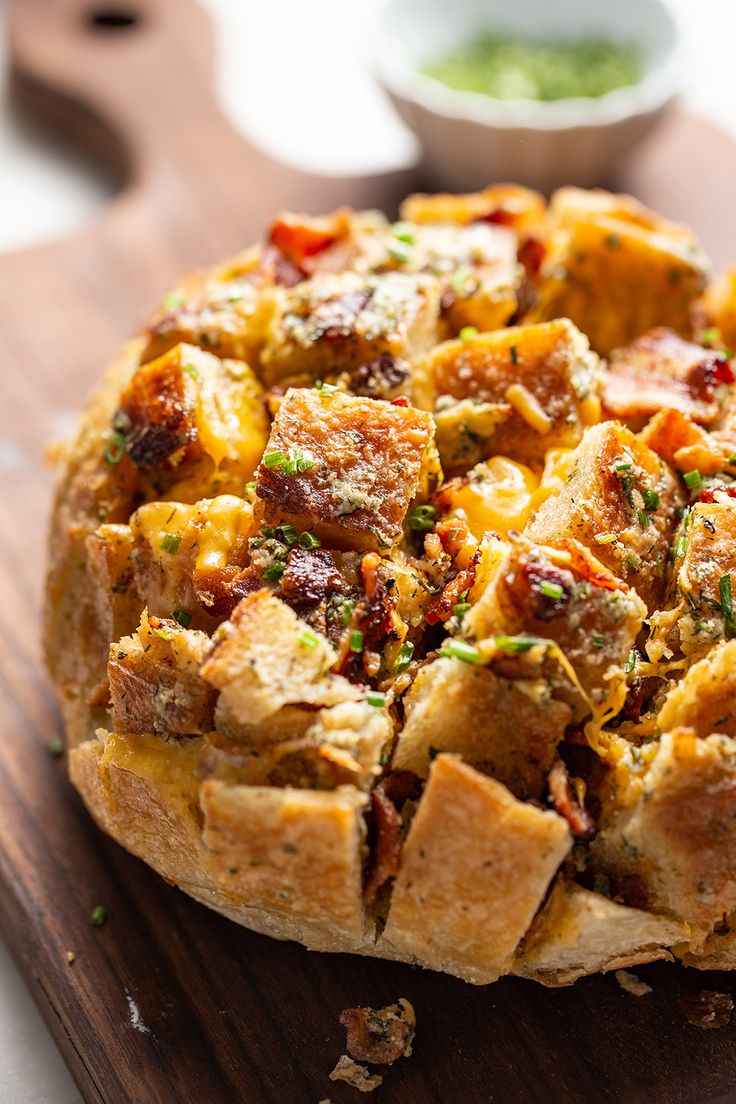 a wooden cutting board topped with a pizza covered in toppings