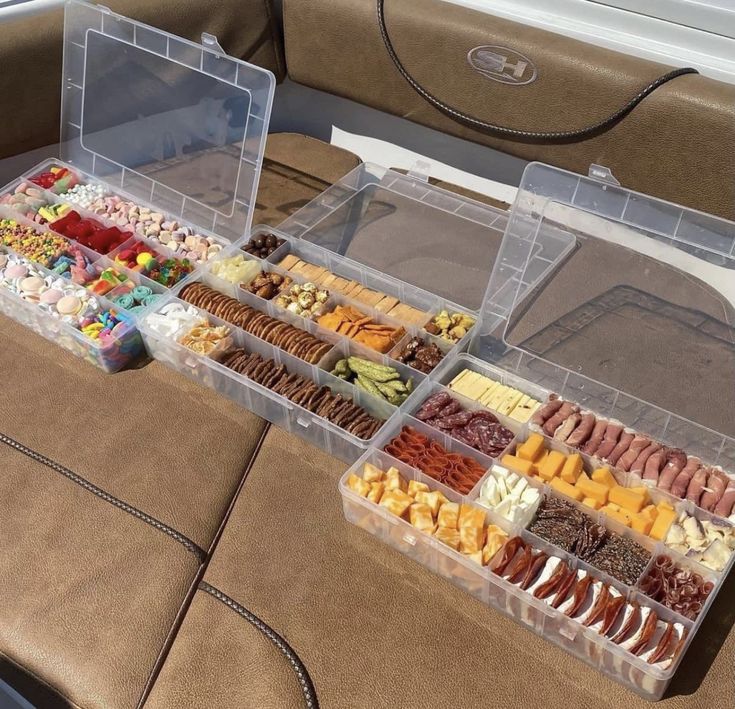 two plastic containers filled with different types of food on a table next to a couch