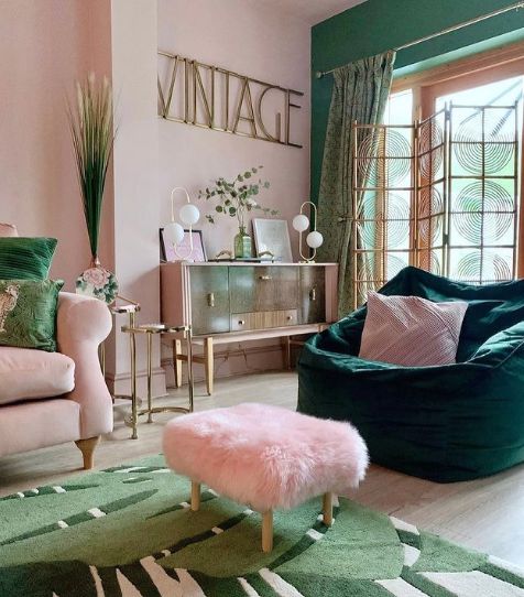 a living room with green and pink furniture, rugs and pillows on the floor