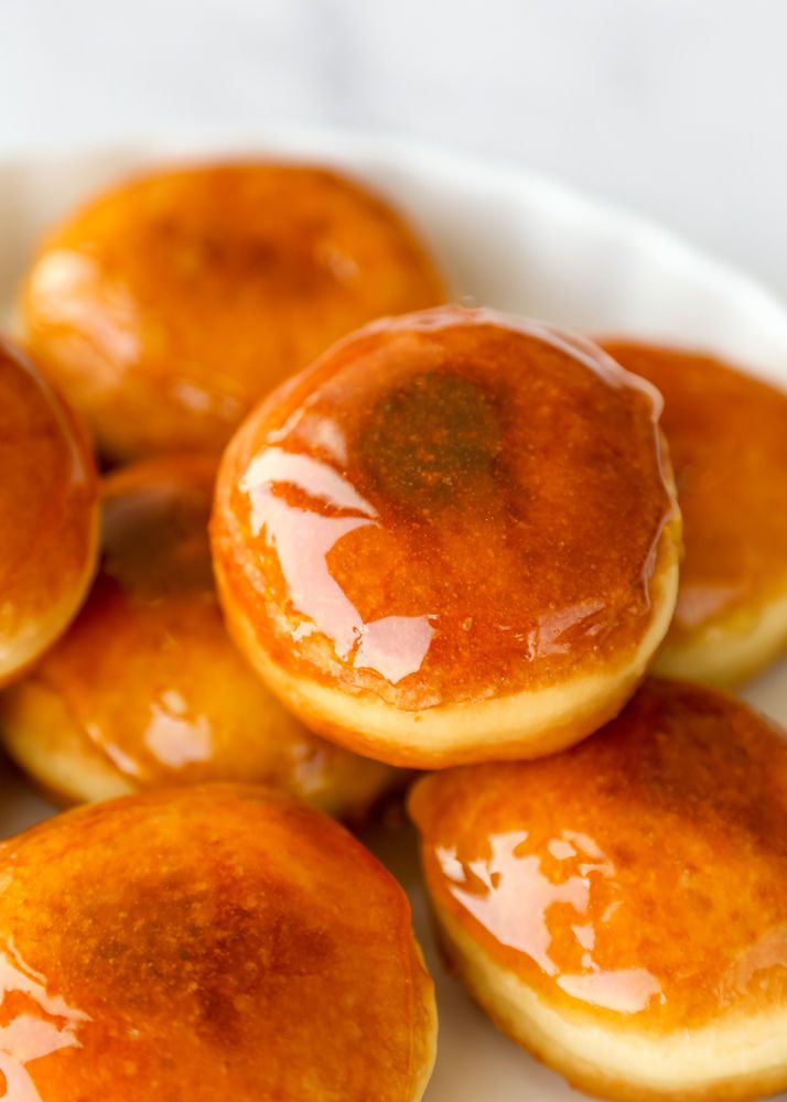 some pancakes are sitting in a bowl on a table with orange syrup drizzled all over them