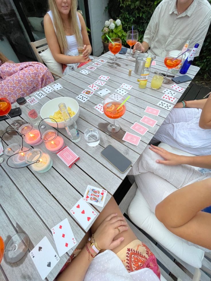 people sitting around a table with cards on it