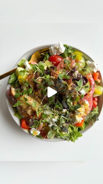 a white plate topped with a salad covered in lots of veggies