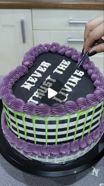 a person cutting into a cake with purple frosting