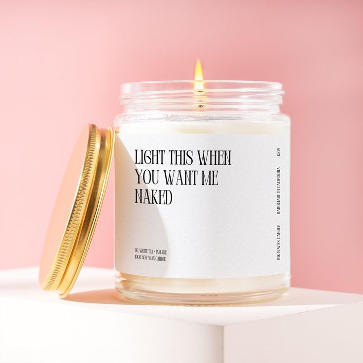 a candle with a quote on it sitting next to a gold container that says, i wish this when you want me naked