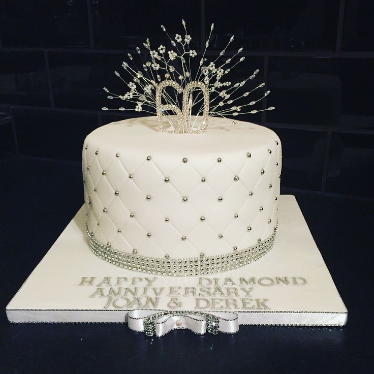 a white cake with silver decorations on top and the number twenty two is displayed in front of a black background