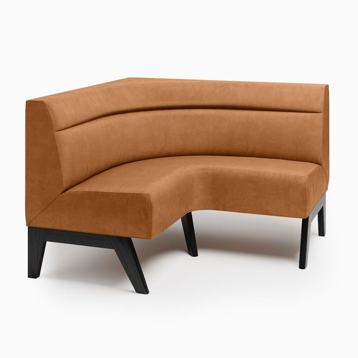 an orange curved couch sitting on top of a wooden table