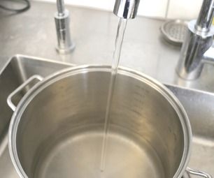 a kitchen sink with a large metal pan on it