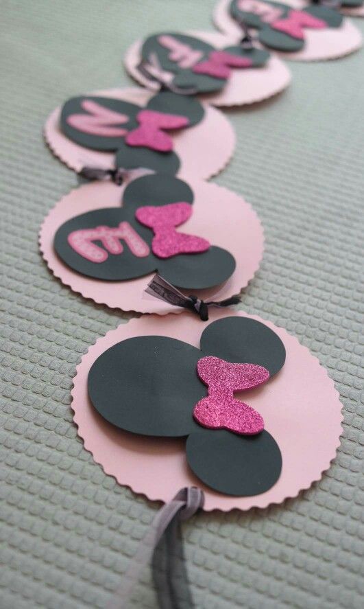 pink and black minnie mouse party decorations on a table with silverware in the middle