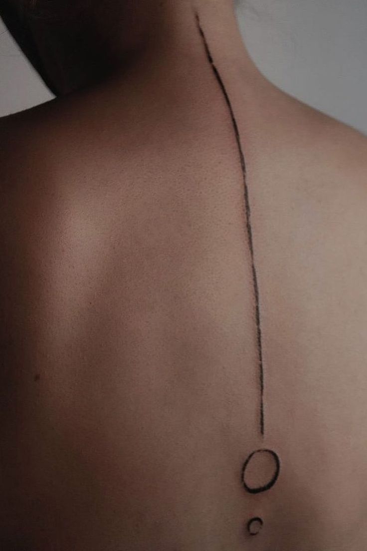 the back of a man's neck with an oval and circle tattoo on it