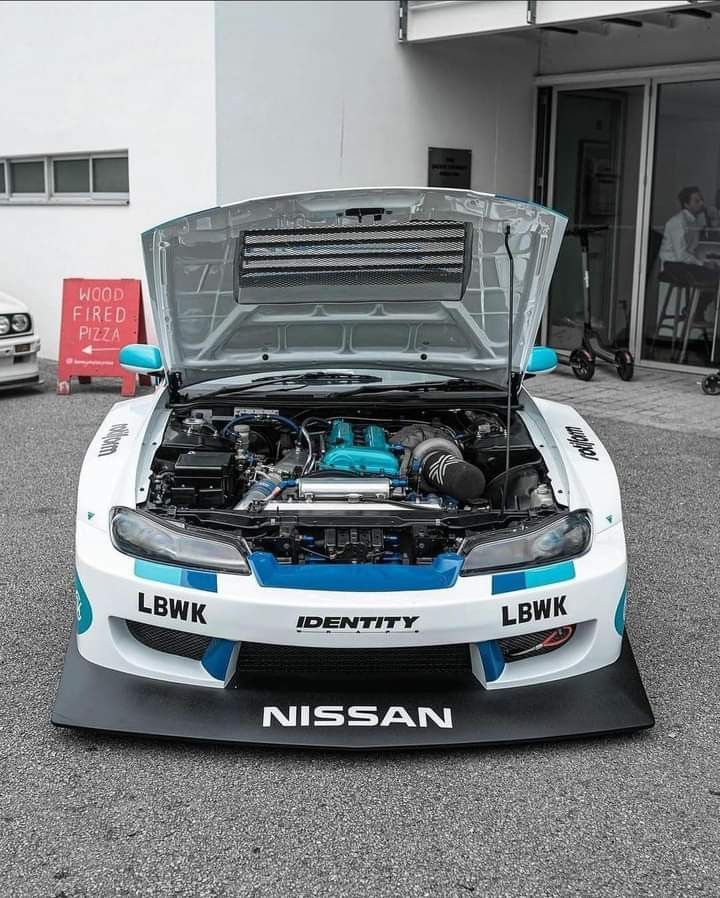 a white and blue sports car with its hood open