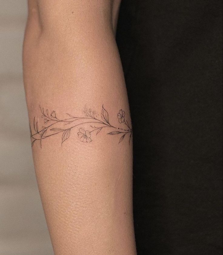 a woman's arm with flowers and leaves tattooed on the left side of her body