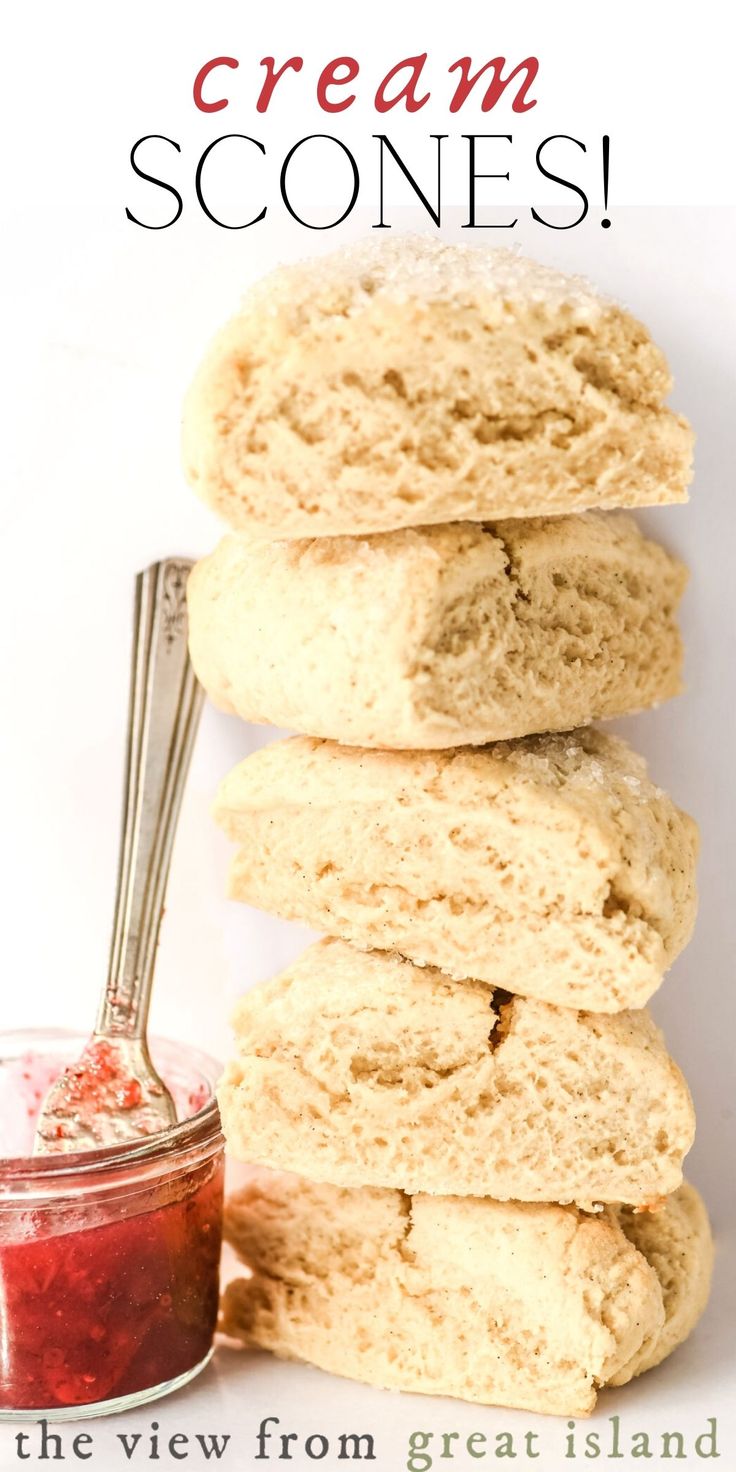 a stack of cream scones next to a jar of jam on a white background