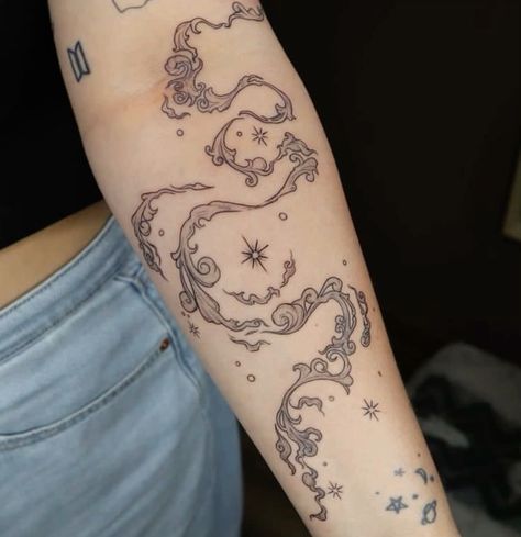 a woman's arm with a tattoo on it that has an image of a horse and stars