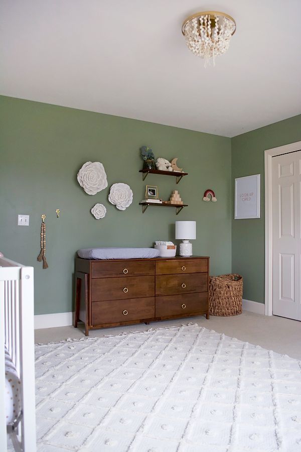 a baby's room with green walls and white carpet