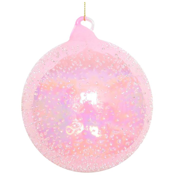 a pink ornament hanging from a string on a white background with glitters