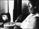 a black and white photo of a woman eating food